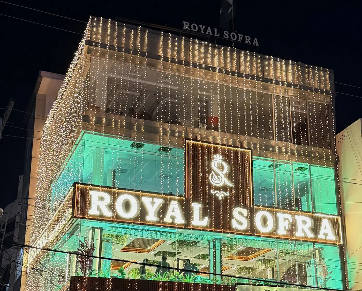 Royal Sofra's green-lit front at night